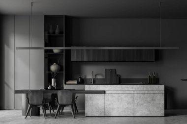 Front view on dark kitchen room interior with dining table, armchairs, grey wall, concrete floor, cupboard, island. Concept of minimalist design. 3d rendering