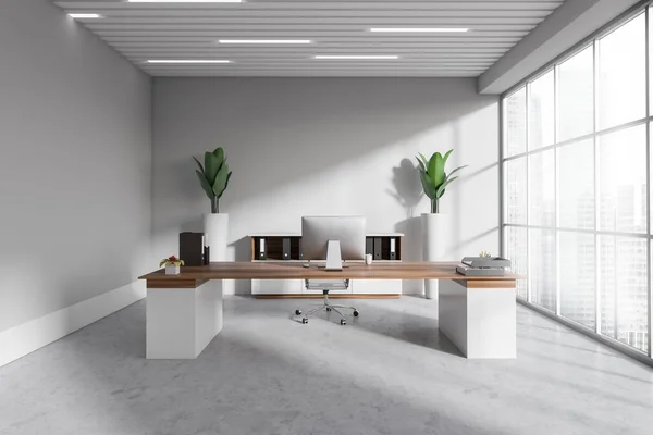 Front view on bright office room interior with desktop, desk, armchair, panoramic window with city view, concrete floor, carpet, sideboard. Concept of company, firm, director workspace. 3d rendering