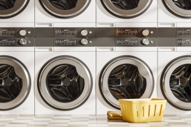 Close up view on bright laundry room interior with eight washing machines, basket, tidy towels, concrete tile floor. Concept of place for washing clothes. 3d rendering