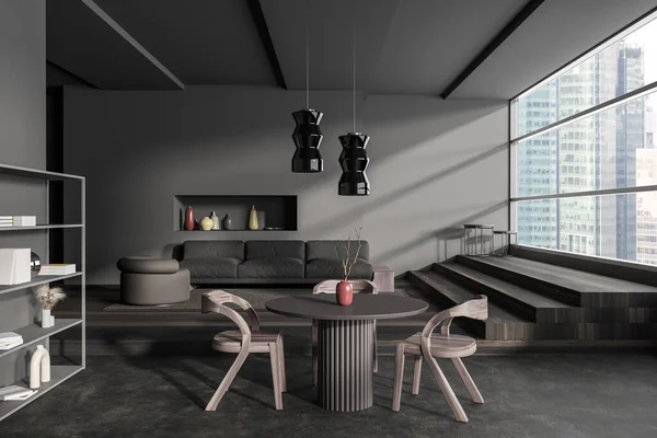 Dark living room interior with dining table and armchairs, sofa on wooden podium. Shelf with decoration, stairs near panoramic window on skyscrapers. 3D rendering