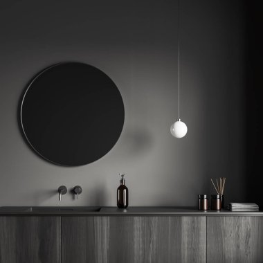 Dark bathroom interior with sink and round mirror, lamp and black wooden deck. Bathing accessories, towel reed diffuser and bath gel. 3D rendering