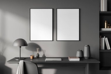 Home office interior with laptop computer and books on desk. Office tools and decoration on shelf. Two mockup posters on grey wall. 3D rendering