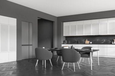 Grey kitchen interior with armchairs and eating table on black hardwood floor, side view. Kitchenware, sink and fridge. Open space cooking area. 3D rendering
