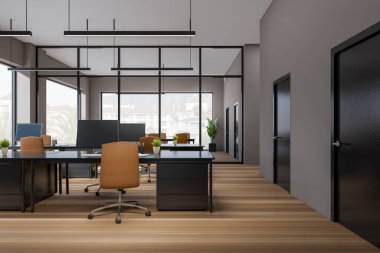 Dark coworking interior with armchairs and pc computer on table, hardwood floor. Open work space with panoramic window on countryside. 3D rendering