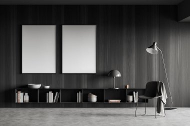 Dark lounge zone interior with chair and lamp, dresser with art decoration, grey concrete floor. Two mock up blank poster on black wooden wall. 3D rendering