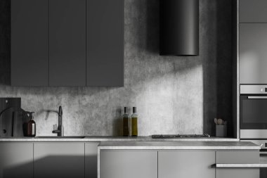 Front close up view on dark kitchen room interior with cupboard, grey wall, island, gas cooker, double oven, sink, cooking inventory, desks. Concept of minimalist design. 3d rendering