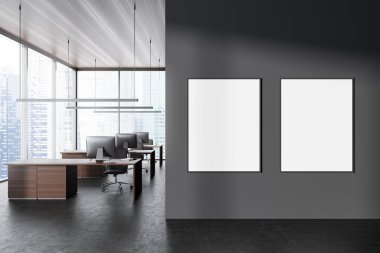 Front view on dark office room interior with two empty white posters, computers, desks, armchair, panoramic window with skyscraper view, concrete floor. Concept of company, firm. Mock up. 3d rendering