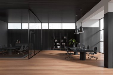 Dark business interior with coworking space and conference zone behind glass doors, pc computer on black wooden work desk. Panoramic window on skyscrapers. 3D rendering