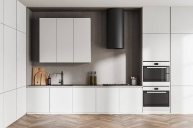 Front view on bright kitchen room interior with cupboard, white wall, oak wooden hardwood floor, gas cooker, double oven, sink, cooking inventory, desks. Concept of minimalist design. 3d rendering