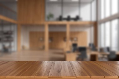 Wooden desk on foreground, background of blurred coworking interior with armchairs and pc computer, two storey loft with panoramic window. Mockup for product display. 3D rendering
