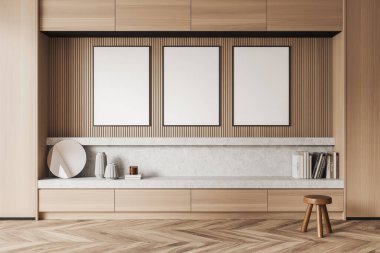Front view on bright living room interior with three empty white posters in a row, shelf with mirror and books, stool, oak wooden hardwood floor. Concept of minimalist design. Mock up. 3d rendering