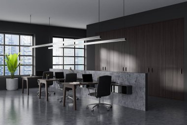 Dark coworking interior with armchairs and laptop on table, grey concrete floor. Workspace with panoramic window on Singapore city view. 3D rendering