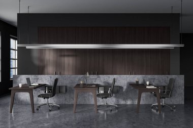 Dark office interior with armchairs and laptop on table in row, grey concrete floor. Modern workplace with technology, window on Singapore city view. 3D rendering