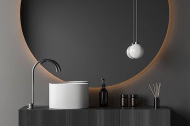 Close up view on dark bathroom interior with large round mirror, sink, white walls, liquid soap, lamp, faucet. 3d rendering