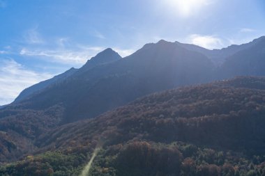 Mountain summits, hillside under light blue sky with clouds. Panoramic view of green hills. Concept of travel and eco tourism