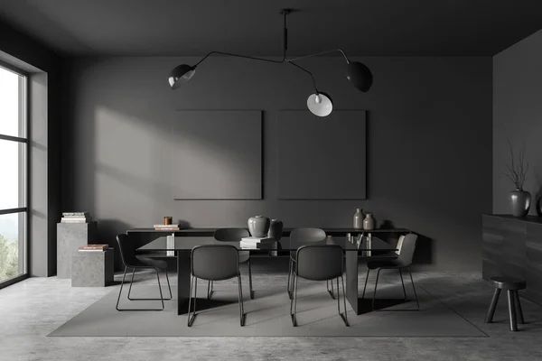 Dark living room interior with chairs and table on carpet, grey concrete floor. Shelf and stand with art decoration, panoramic window on countryside. Two black mockup canvas. 3D rendering