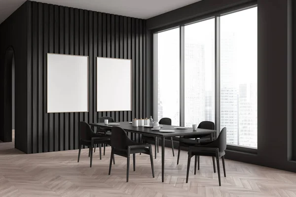Dark living room interior with dinner table and chair, side view hardwood floor. Panoramic window on skyscrapers. Two blank mockup posters. 3D rendering