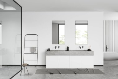 White bathroom interior with sink, mirror and bathtub on grey concrete floor, window on tropics. Table with towel and rail ladder, modern hotel studio. 3D rendering
