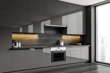 Dark kitchen interior with stove and oven. Deck with kitchenware and dishes, black hardwood floor. Panoramic window on city view. 3D rendering