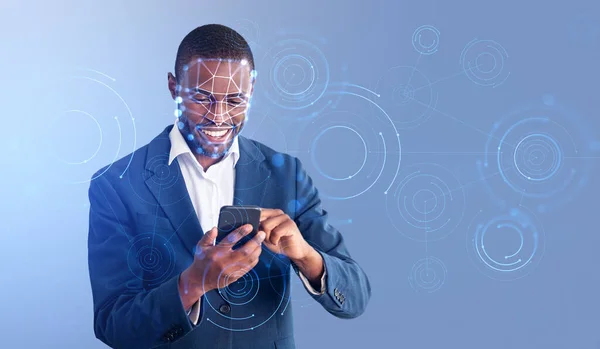 Black smiling businessman using phone, biometric verification and facial recognition. Concept of face id and digital connection