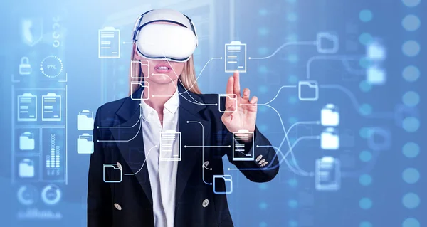 Businesswoman wearing vr headset is watching at metaverse reality with document management system. Blue background. Concept of modern technology and information documentation database