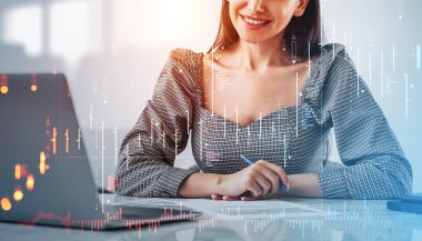 Smiling businesswoman with contract and laptop on desk, office room. Forex diagrams with candlesticks, screen hud with bar chart. Concept of banking and finance