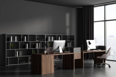 Dark business interior with wooden work table, side view. Pc computer and shelf with documents on grey concrete floor. Coworking corner with panoramic window on skyscrapers. 3D rendering