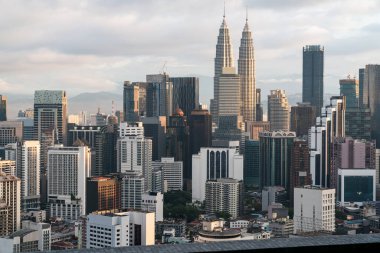 Bulutlu bir günde Petronas ikiz kuleleriyle Kuala Lumpur 'un şehir manzarası. Turizm ve mimari kavramı