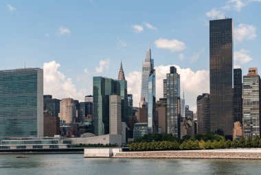 Birleşmiş Milletler karargahı. New York şehir merkezinde açık gökyüzü, rıhtım ve bulutlar altında. Manhattan 'daki, Doğu Nehri' ndeki ve gökdelenlerdeki ofis binaları. 