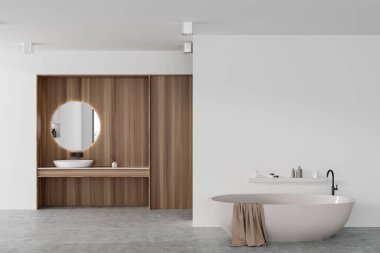Beyaz ve ahşap bir otel banyosu ve gri beton zeminde küveti var. Yuvarlak aynalı lavabo, minimalist aksesuarlar, boş duvarlar. 3B görüntüleme