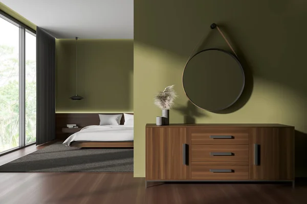 Green hotel bedroom interior with mirror and chest of drawers, bed behind partition on carpet. Panoramic window on tropics. 3D rendering