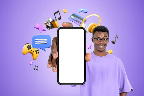 アフリカ人の男性が手にモックアップ電話を表示笑顔 さまざまなデジタル世界のアイコンが浮かんでいます モバイルアプリ オンラインショッピング 販売の概念 — ストック写真
