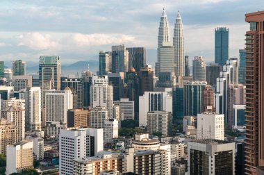 Malezya 'nın Kuala Lumpur şehrinin muhteşem manzarası, bulutlu bir günde finans bölgesi ve Petronas ikiz kuleleri. Mimarlık ve gezi anlayışı