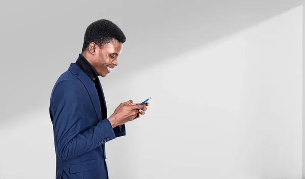 幸せな笑顔で若い黒人ビジネスマンのプロフィールは スマートフォン ライトグレーの背景を参照してください ソーシャルメディアとコミュニケーションの概念 スペースのコピー — ストック写真