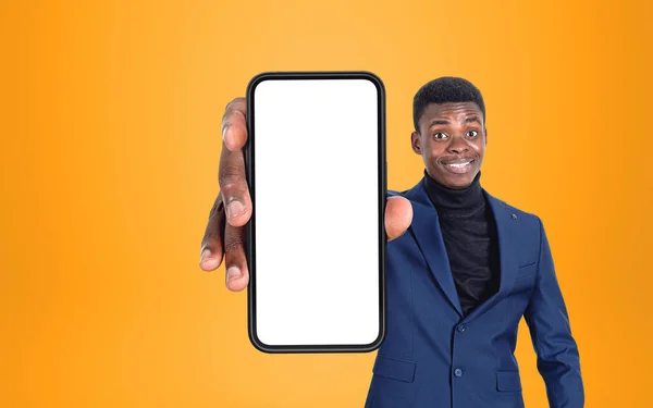 若い黒人ビジネスマンの笑顔は コピースペース画面 黄色の背景をモックアップで電話を示しています モバイルアプリとソーシャルメディアの概念 — ストック写真