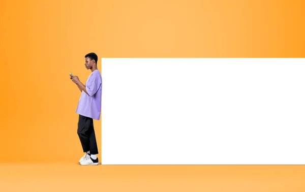 Telefonla Çalışan Siyah Bir Adam Sarı Arka Planda Mesaj Atıyor — Stok fotoğraf