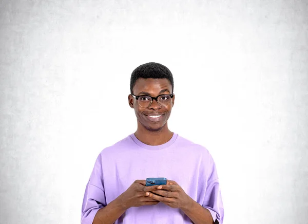 Retrato Sorrir Jovem Afro Americano Óculos Camiseta Roxa Segurando Smartphone — Fotografia de Stock