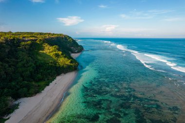 Uçan İHA, kayalık plajı uçurumla panoramik olarak görüntüledi. Hint Okyanusu kıyısında. Uzayı metin için kopyala. Doğa ve seyahat geçmişi. Güzel doğal yaz tatili seyahat konsepti.