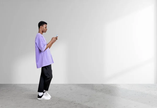 Musta Amerikkalainen Mies Seisoo Älypuhelin Täyspitkä Profiili Valkoisella Pohjalla Harmaa — kuvapankkivalokuva