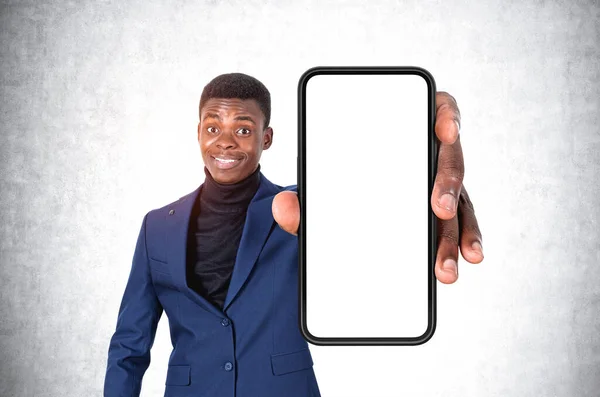 Genç Afrikalı Işadamı Şaşırmış Gülümsüyor Telefonu Boş Bir Alanda Gösteriyor — Stok fotoğraf