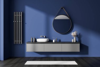 Lavabosu, yuvarlak aynası, çekmecesi ve duvarında havlu korkuluğu olan koyu mavi bir banyo. Siyah ahşap zeminde banyo aksesuarları ve halı. 3B görüntüleme