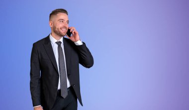 Genç, sakallı, gülümseyen iş adamının portresi. Mor arka planda duran akıllı telefondan konuşuyor. İletişim kavramı. Model