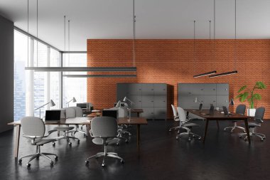 Gri ve tuğlalı duvarları, beton zemini, uzun bilgisayar tabloları, gri dolabı ve bulanık manzaralı büyük pencereleri olan modern açık uzay ofisinin içi. 3d oluşturma