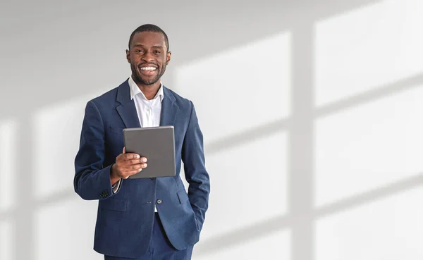 白い背景の上にタブレットコンピュータを保持する若いアフリカ系アメリカ人ビジネスマンの笑顔 ハイテクの概念 モックアップ — ストック写真