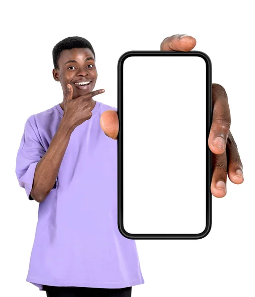 黒の若い男の笑顔 指のコピースペースの画面をモックアップ大規模なスマートフォンを指して 白い背景に孤立した ソーシャルメディアとオンラインショッピングの概念 — ストック写真