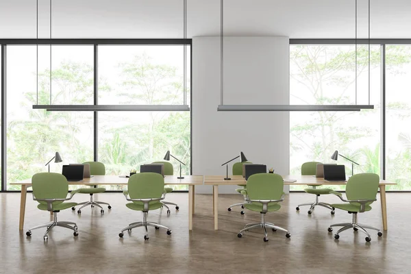 White office interior with green armchairs and laptop on a shared table in row, beige concrete floor. Coworking space and panoramic window on tropics. 3D rendering