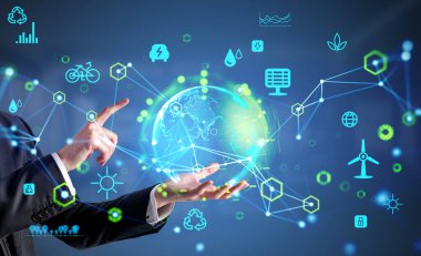 İşadamı tutarak ve parmaklarıyla Dünya 'ya dokunarak hologram oluşturdu. Değişik simgelerle parlayan eko gövde. Ekosistem ve gelecekteki teknoloji. Yenilenebilir kaynaklar kavramı