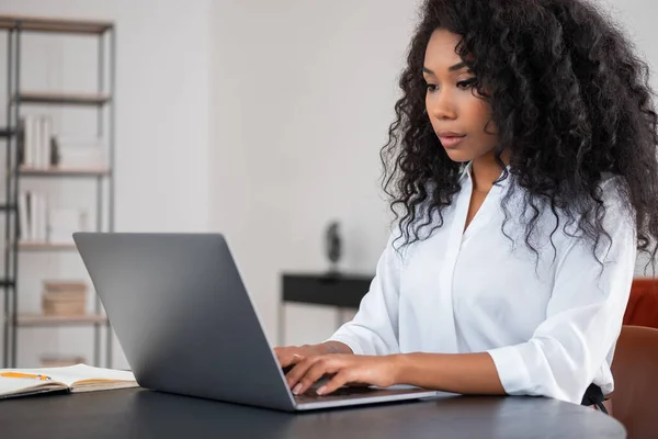 Black Businesswoman Typing Laptop Looking Screen Office Room Shelf Blurred — Stock Photo, Image