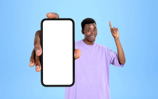 青空に幸せな黒い男の指ポイントは 青い背景にコピースペースのディスプレイをモックアップで電話を示しています ソーシャルメディアとウェブサイトの概念 — ストック写真