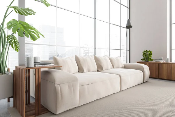 stock image White living room interior with sofa, side view, coffee table and drawer with decoration, carpet on grey concrete floor. Stylish chill corner with panoramic window on city view. 3D rendering